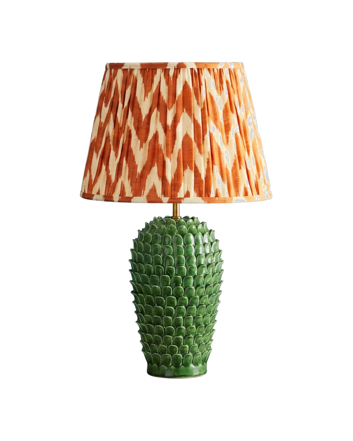 A green ceramic table lamp with a pleated ikat shade